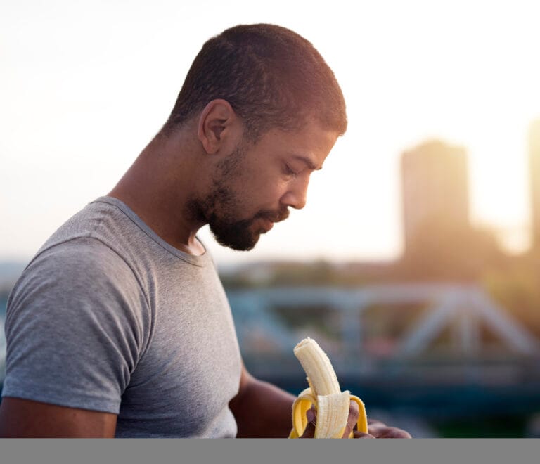 young sportsman eating banana after training 1